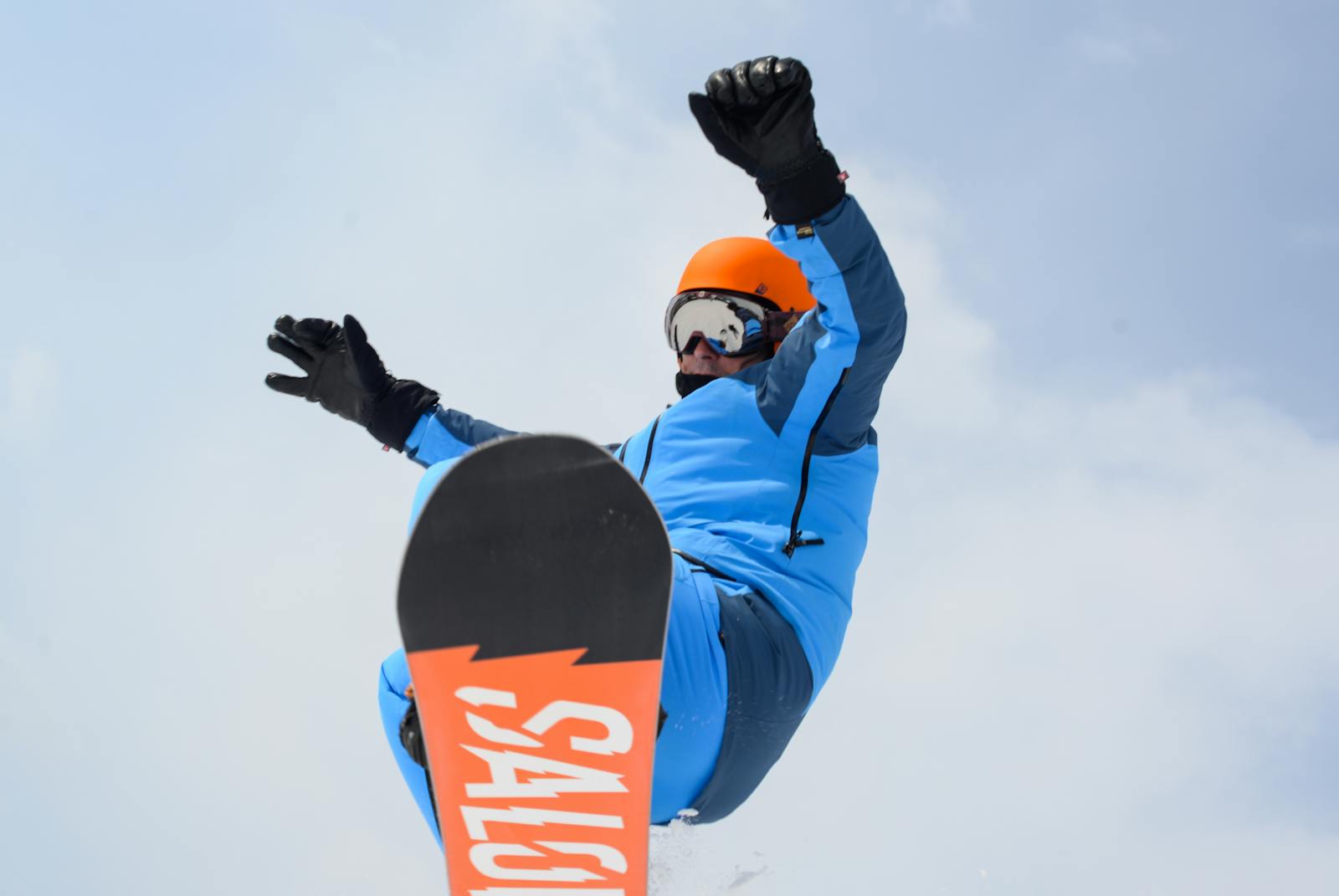 Action-packed shot of snowboarder mid-jump against a winter sky, showcasing skill and style.